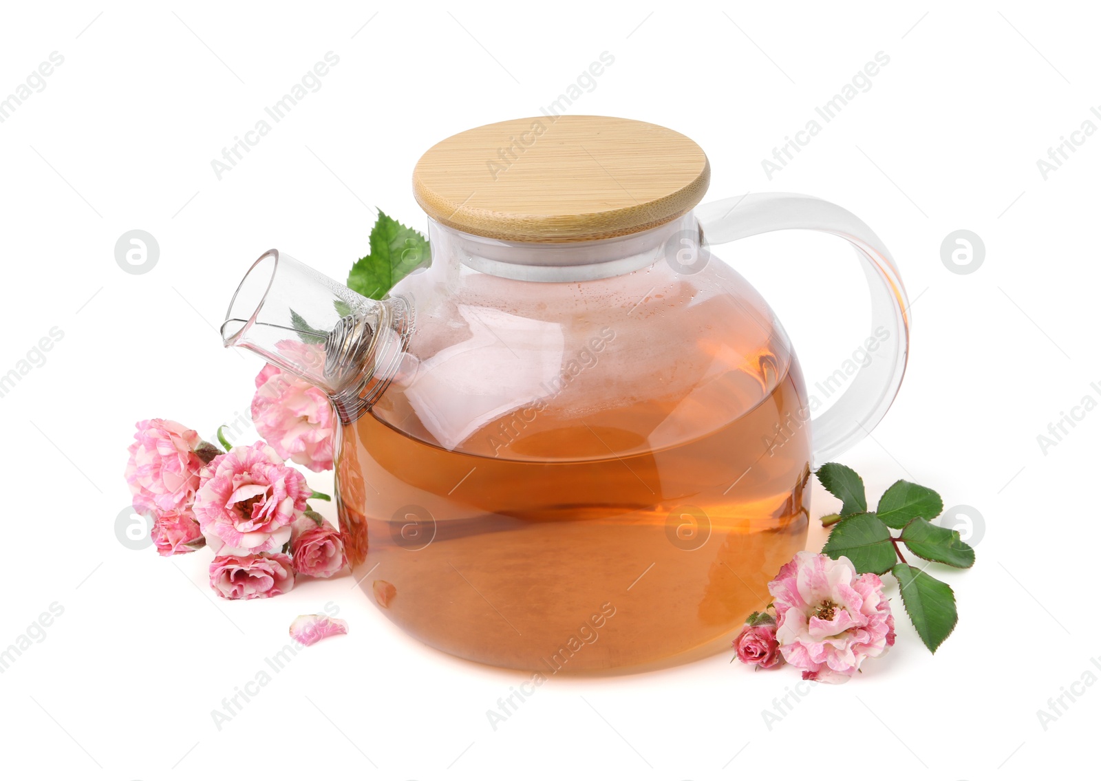 Photo of Tasty rose tea in glass teapot, flowers and leaves isolated on white