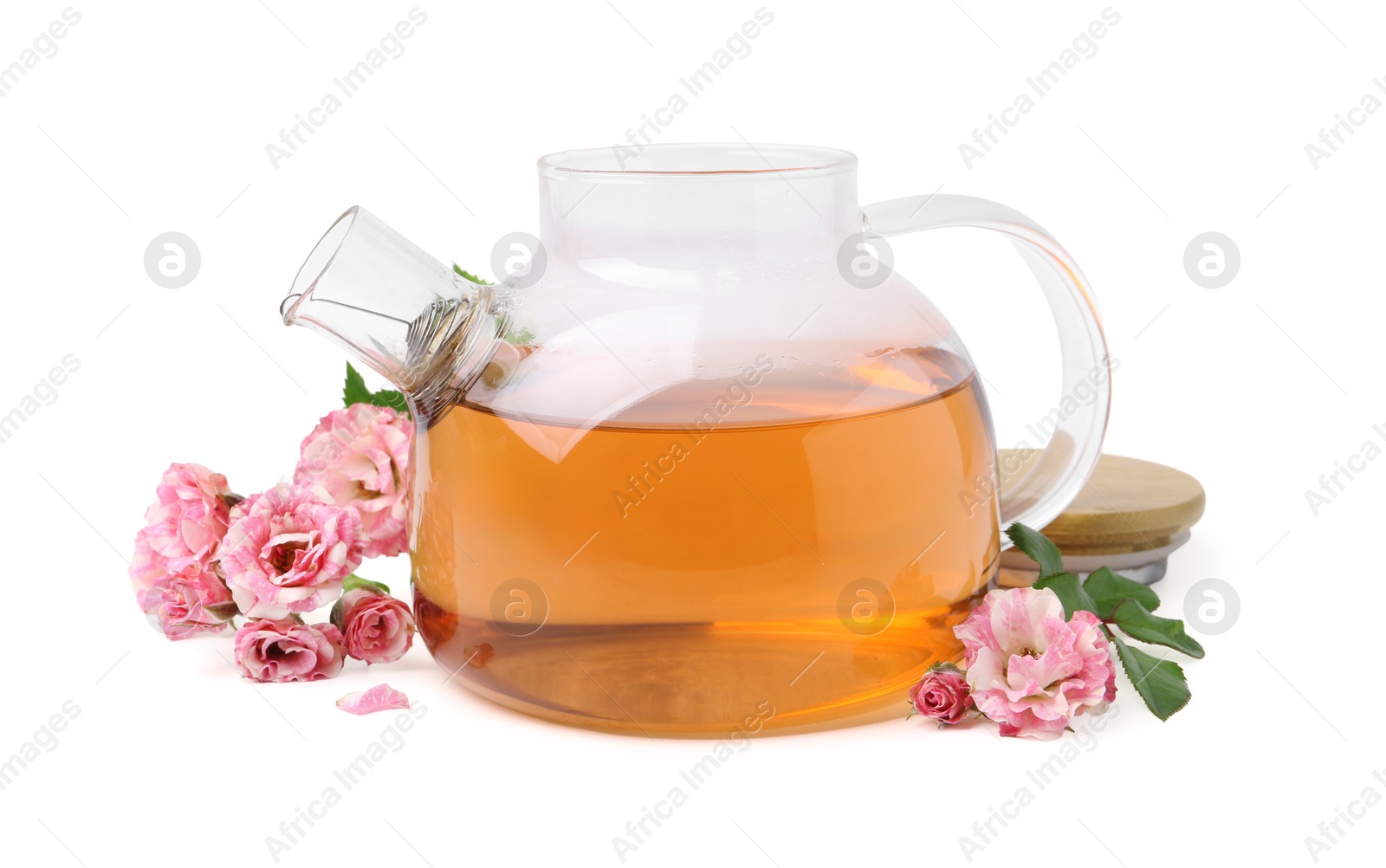 Photo of Tasty rose tea in glass teapot, flowers and leaves isolated on white