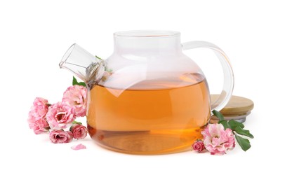 Photo of Tasty rose tea in glass teapot, flowers and leaves isolated on white