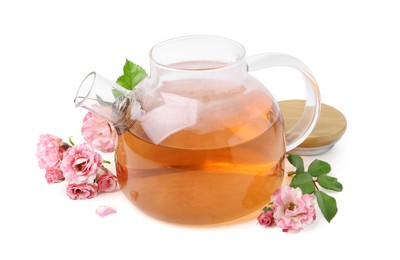 Photo of Tasty rose tea in glass teapot, flowers and leaves isolated on white