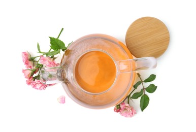 Photo of Tasty rose tea in glass teapot, flowers and sprig with leaves isolated on white, top view