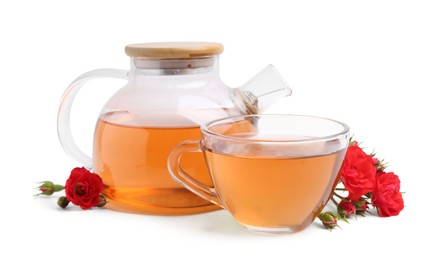 Photo of Tasty rose tea in glass cup, teapot and flowers isolated on white