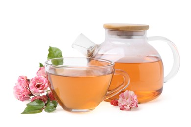 Photo of Tasty rose tea in glass cup, teapot and flowers isolated on white