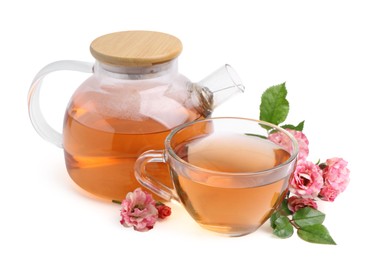 Photo of Tasty rose tea in glass cup, teapot and flowers isolated on white