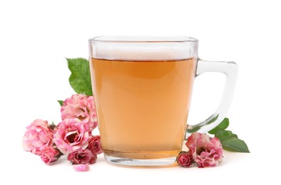 Photo of Tasty rose tea in glass cup and flowers isolated on white
