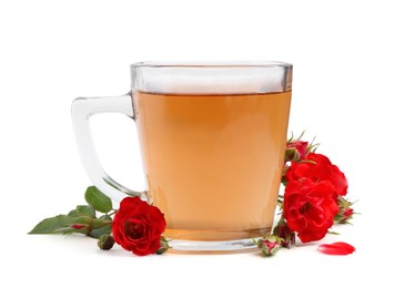 Photo of Tasty rose tea in glass cup and flowers isolated on white