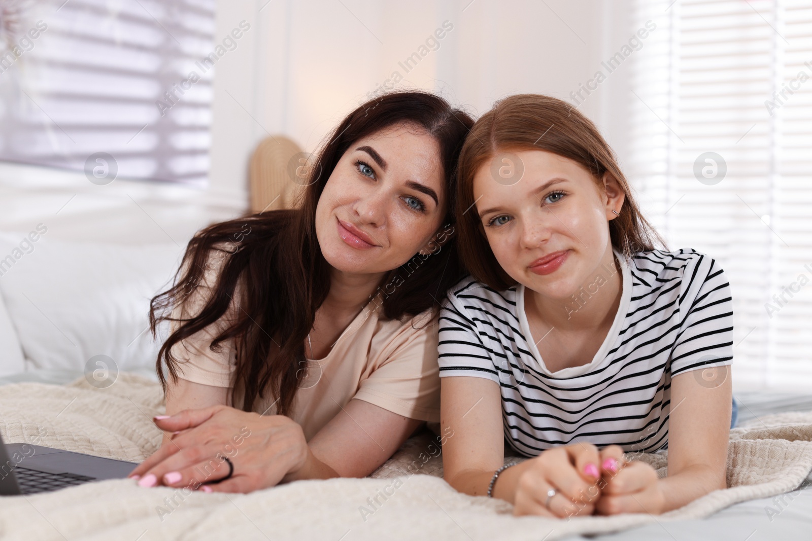 Portrait of mother and her teenage daughter on bed at home Photo of Portrait of mother and her teenage daughter on bed at home