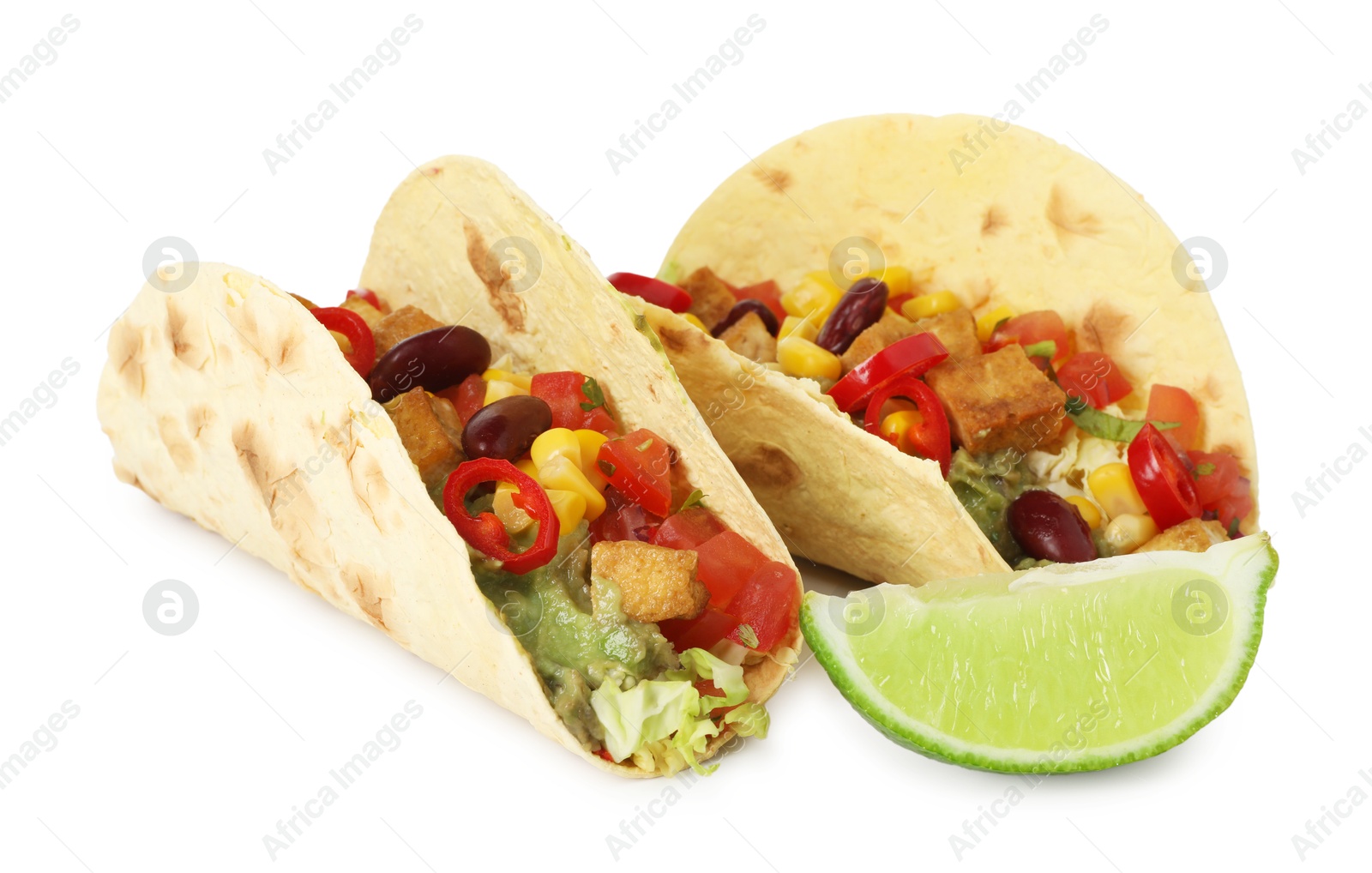 Photo of Tasty vegetarian tacos with beans, tofu, vegetables, guacamole and lime isolated on white