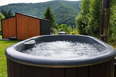 Photo of Tub with hot water at luxury resort in mountains, closeup