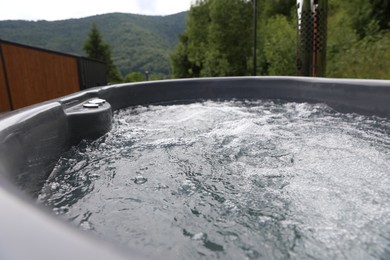 Photo of Tub with hot water at luxury resort in mountains, closeup