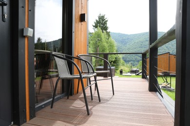 Photo of Rattan chairs on outdoor terrace at luxury resort in mountains