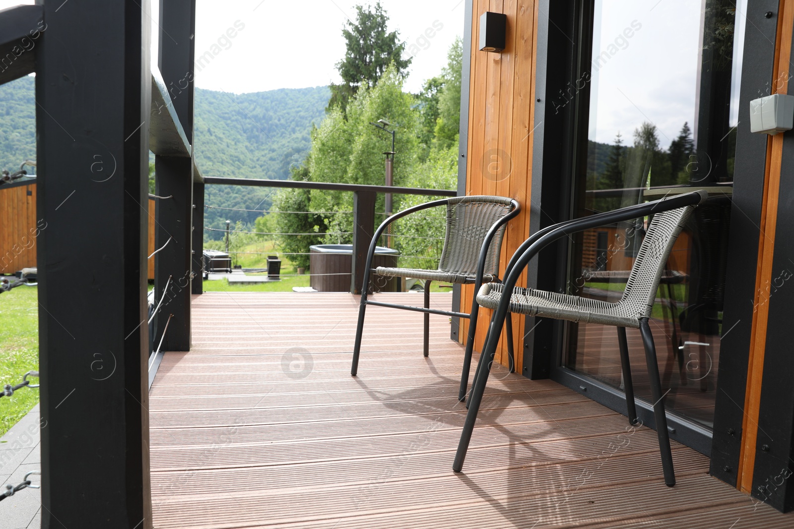 Photo of Rattan chairs on outdoor terrace at luxury resort in mountains