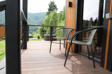 Photo of Rattan chairs on outdoor terrace at luxury resort in mountains