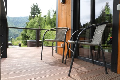 Photo of Rattan chairs on outdoor terrace at luxury resort in mountains