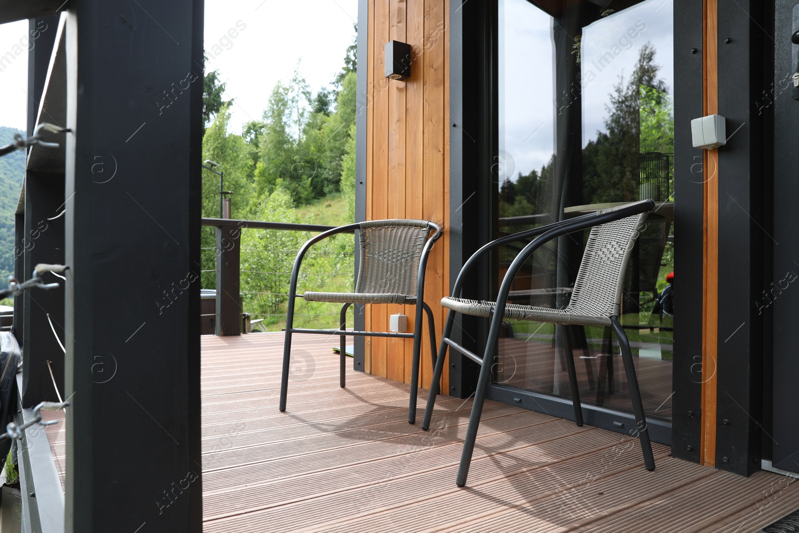 Photo of Rattan chairs on outdoor terrace at luxury resort in mountains