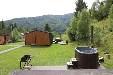Photo of Tub with hot water and buildings at luxury resort in mountains