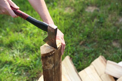 Photo of Man chopping firewood with axe outdoors, closeup. Space for text