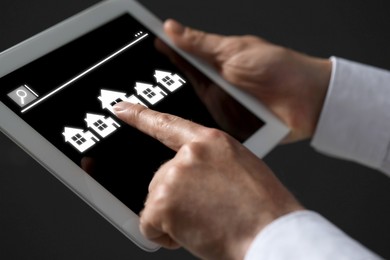 Image of Searching for housing online. Real estate agent using tablet computer, closeup. Search bar and house icons on device screen
