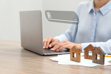 Image of Searching for housing online. Real estate agent using laptop at table with house models, closeup. Search bar above computer
