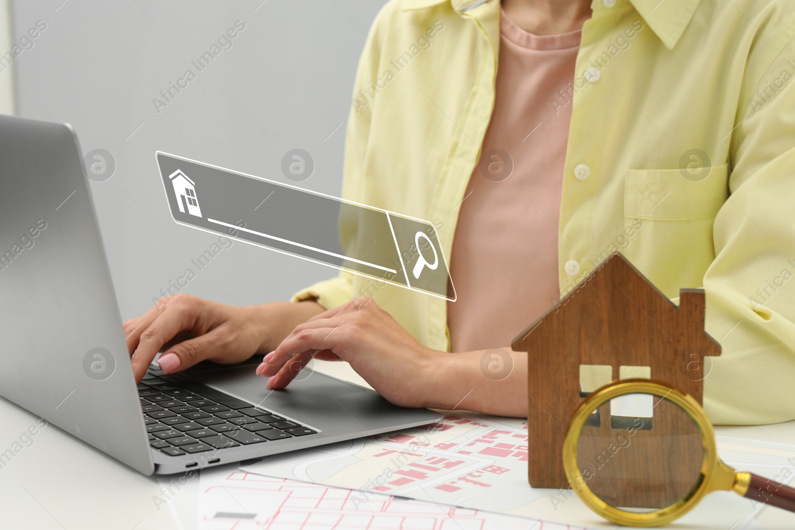 Image of Searching for housing online. Real estate agent using laptop at table with magnifying glass and house model, closeup. Search bar above computer
