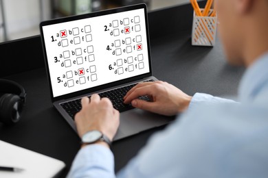 Image of Man passing online test on laptop at table, closeup