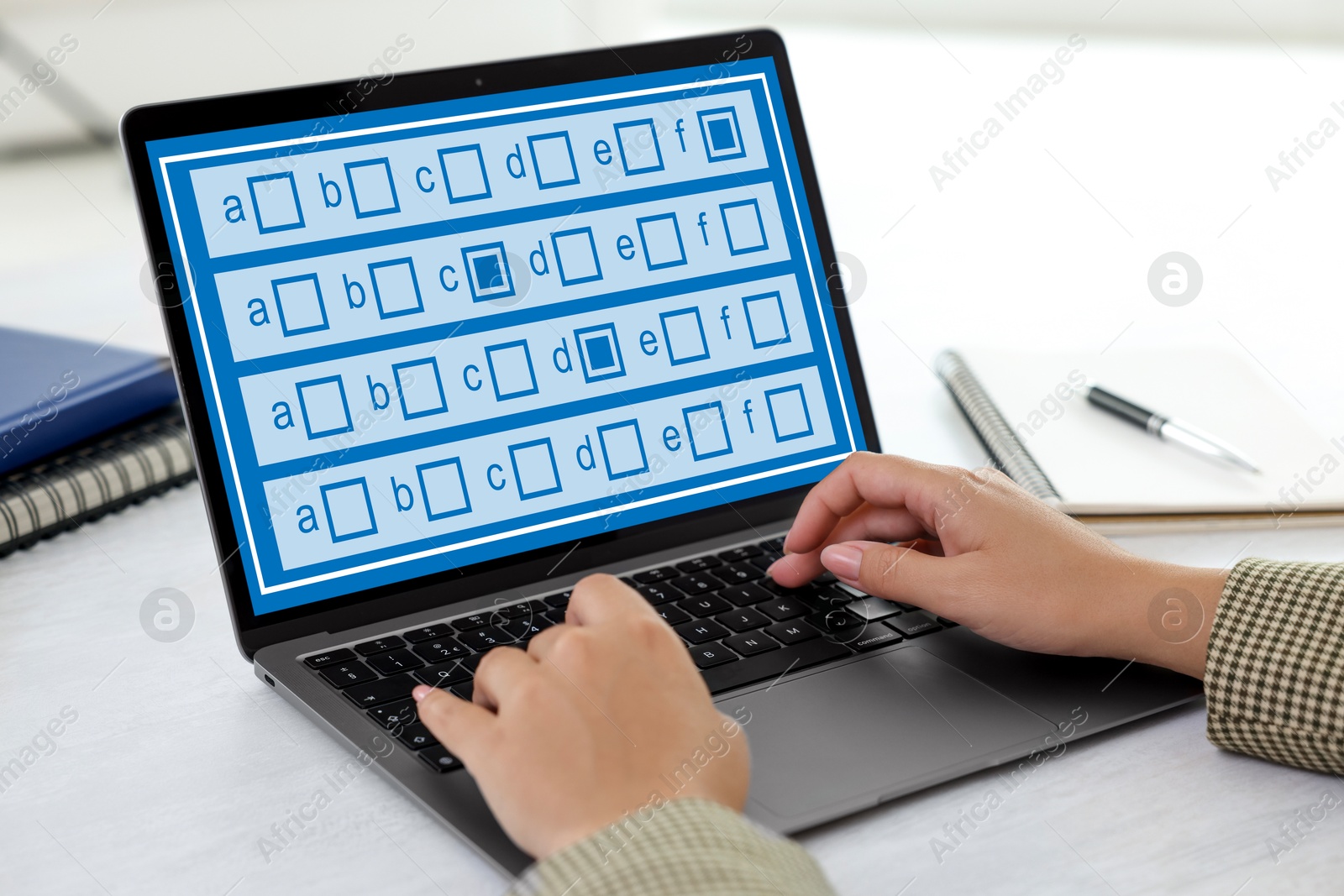 Woman passing online test on laptop at table, closeup Image of Woman passing online test on laptop at table, closeup