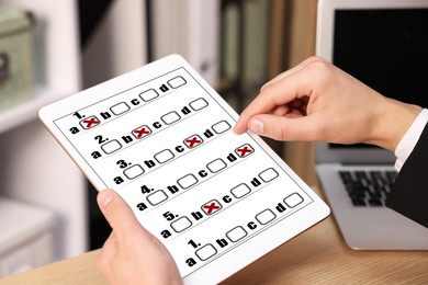 Image of Man passing online test on tablet computer at table, closeup