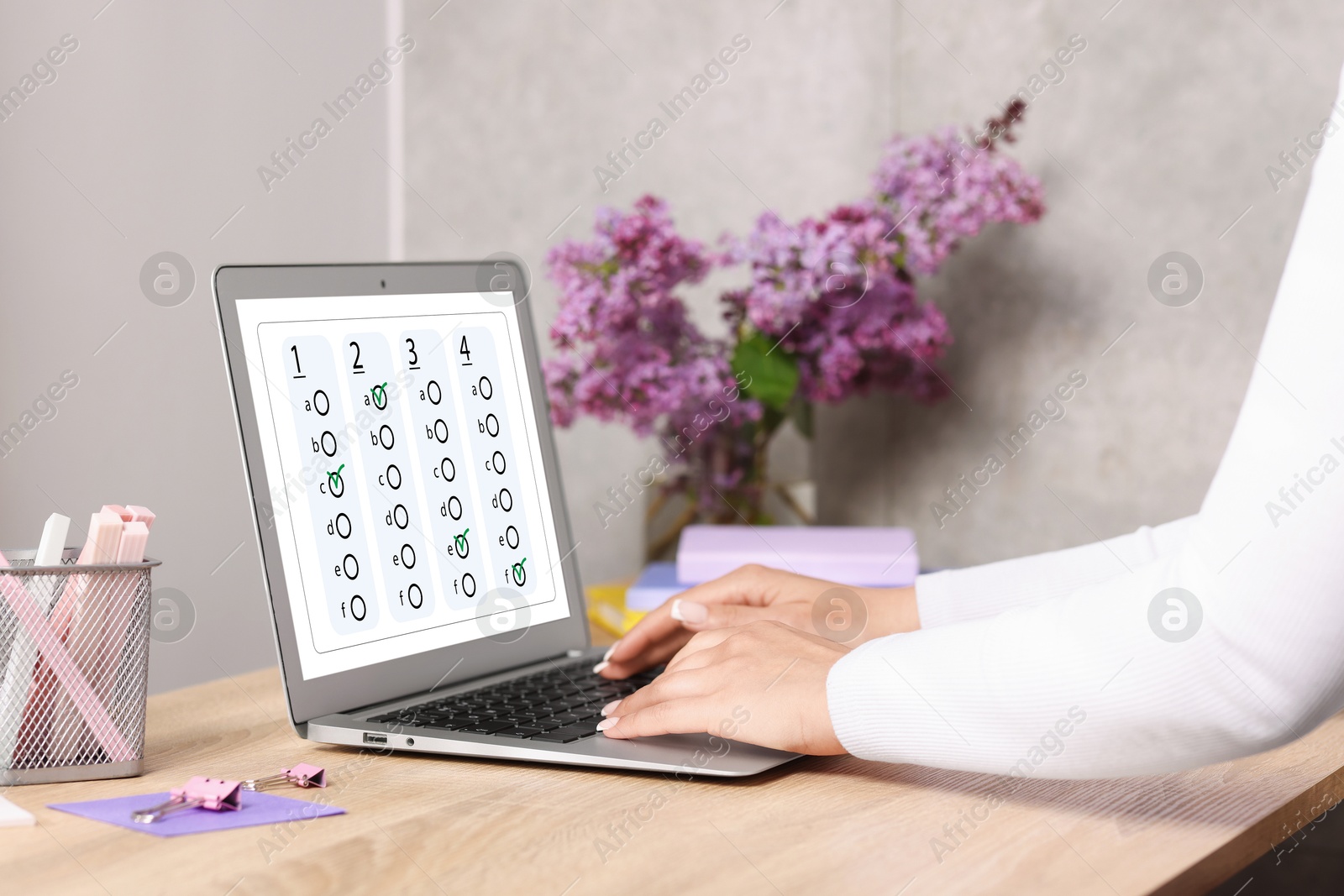 Woman passing online test on laptop at table, closeup Image of Woman passing online test on laptop at table, closeup