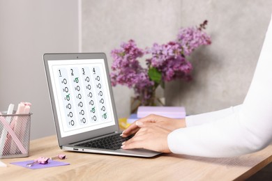 Image of Woman passing online test on laptop at table, closeup