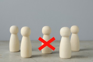 Image of Dismissal. One human figure with red cross among others on grey table