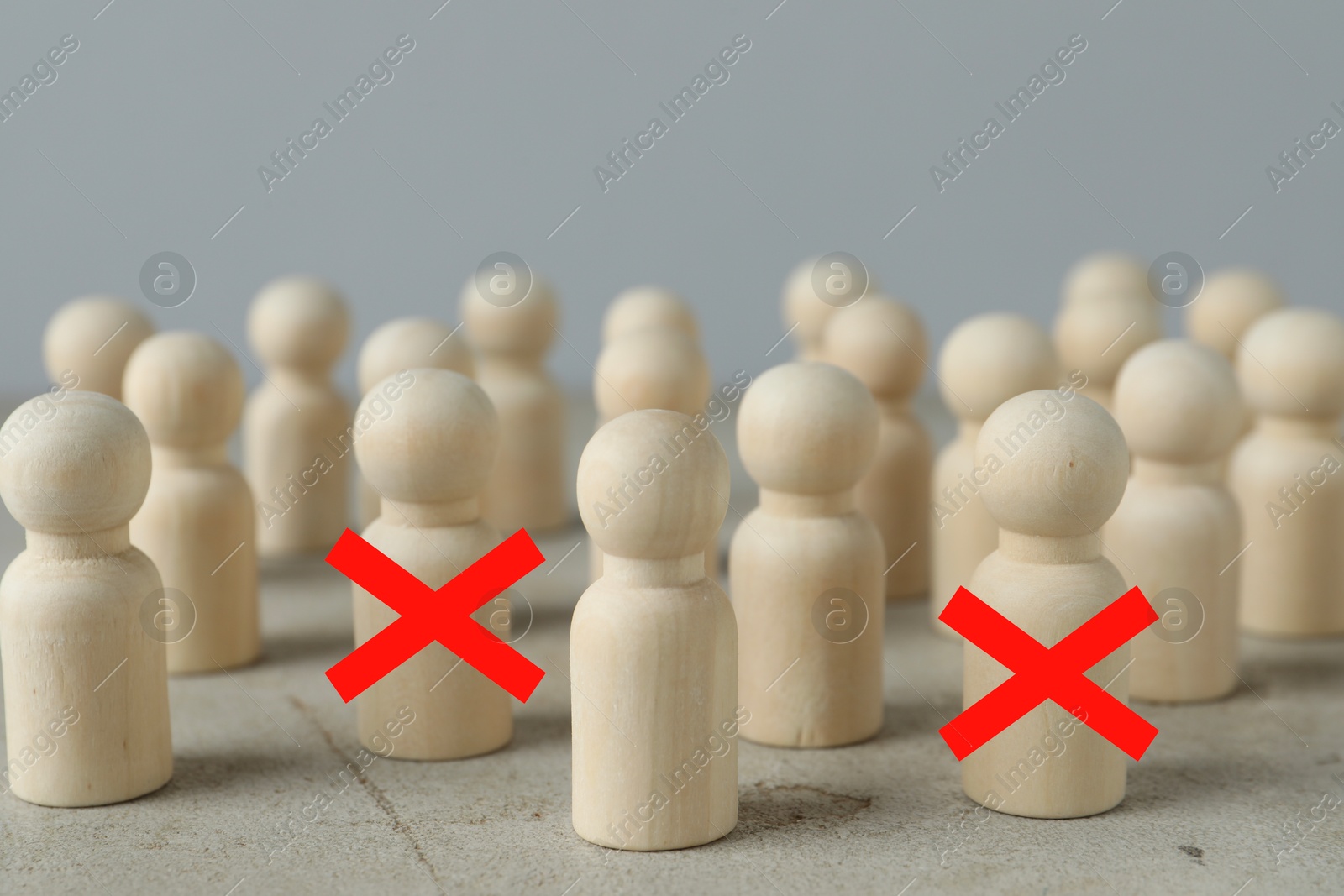 Dismissal. Two human figures with red crosses among others on grey table Image of Dismissal. Two human figures with red crosses among others on grey table