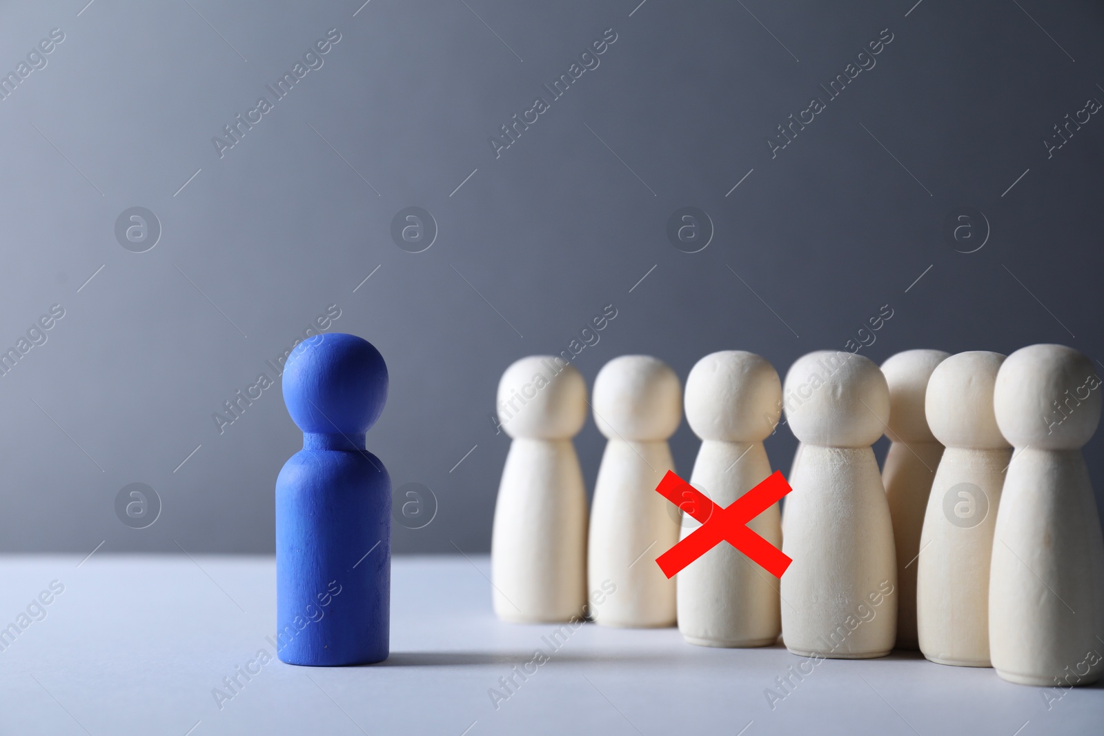 Dismissal. One human figure with red cross among others on grey table Image of Dismissal. One human figure with red cross among others on grey table