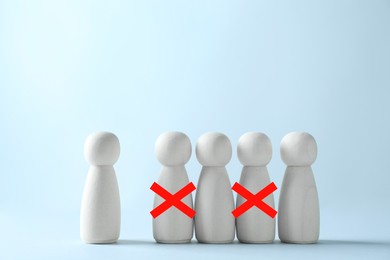 Image of Dismissal. Two human figures with red crosses among others on grey table