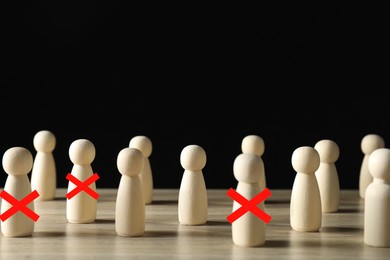 Image of Dismissal. Three human figures with red crosses among others on wooden table