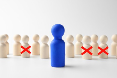 Image of Dismissal. Three human figures with red crosses among others on white table. Blue figure - boss or HR manager