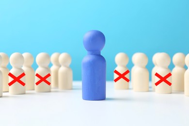 Image of Dismissal. Four human figures with red crosses among others on white table. Blue figure - boss or HR manager