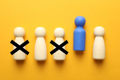 Image of Dismissal. Two human figures with black crosses among others on orange background, top view. Blue figure - boss or HR manager
