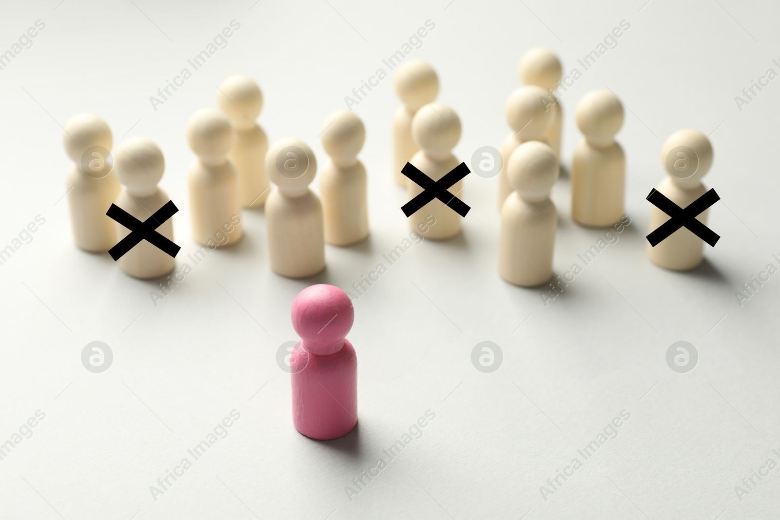 Dismissal. Three human figures with black crosses among others on white table. Pink figure - boss or HR manager Image of Dismissal. Three human figures with black crosses among others on white table. Pink figure - boss or HR manager