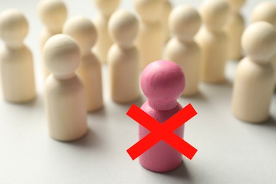 Image of Dismissal. One pink human figure with red cross among others on white table