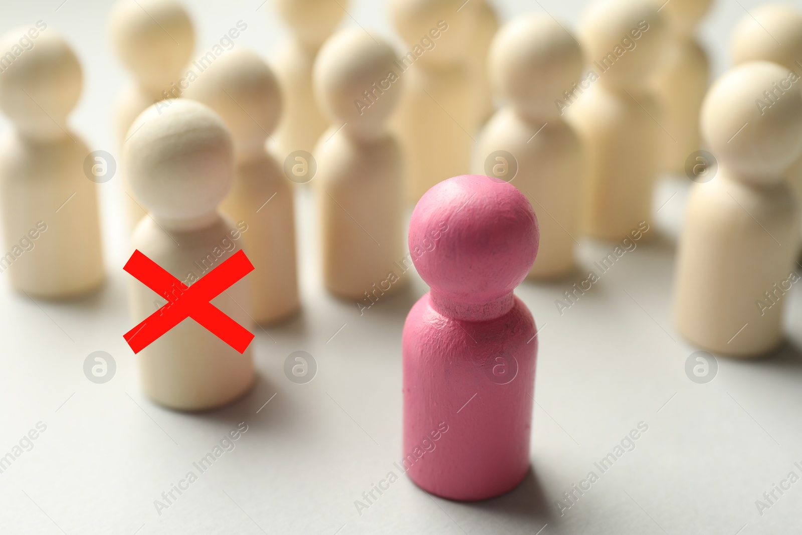 Dismissal. One human figure with red cross among others on white table. Pink figure - boss or HR manager Image of Dismissal. One human figure with red cross among others on white table. Pink figure - boss or HR manager