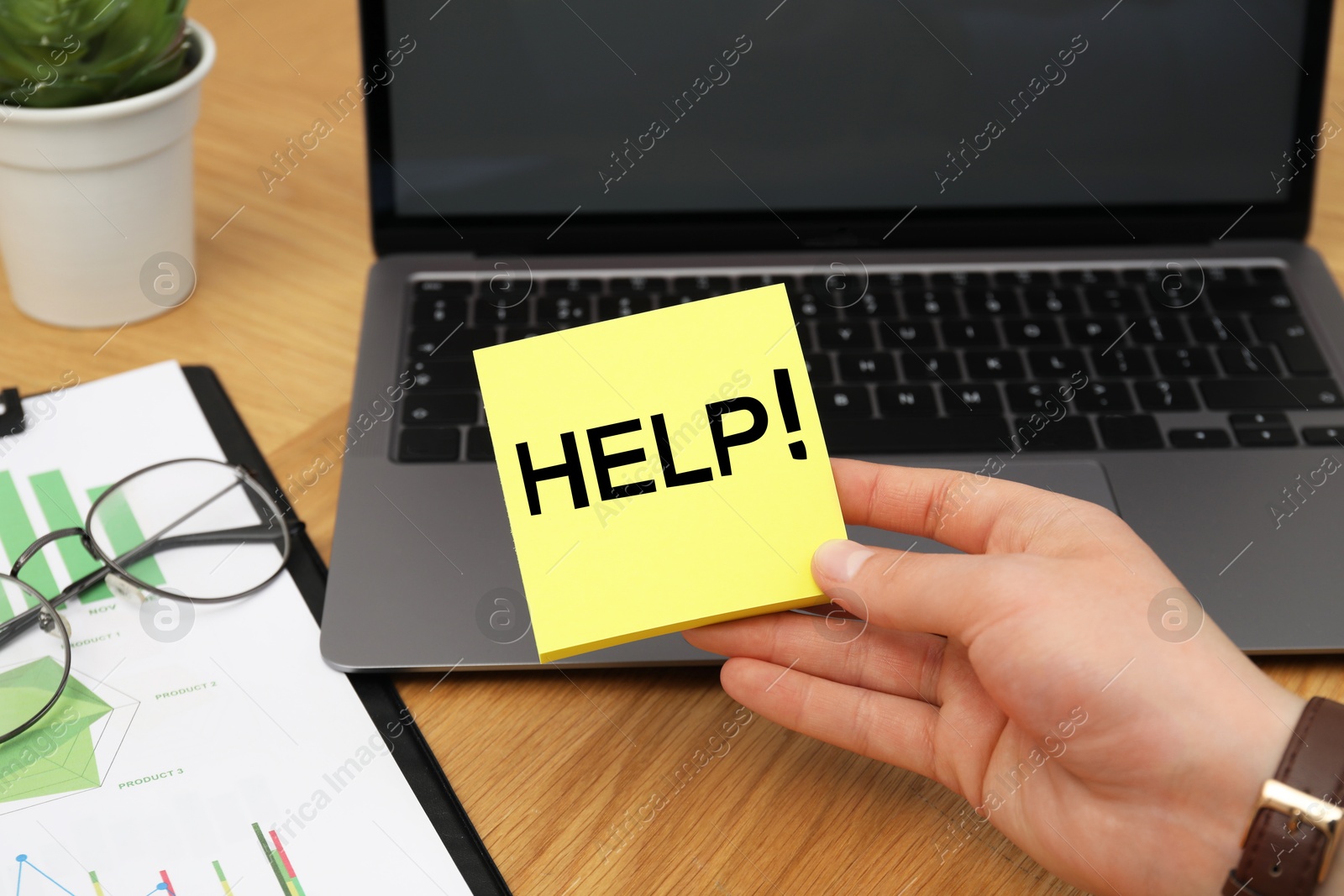 Image of Man holding paper notes with word Help at workplace, closeup