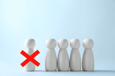 Image of Dismissal. One human figure with red cross among others against light blue background