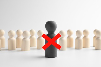 Image of Dismissal. One grey human figure with red cross among others on white table