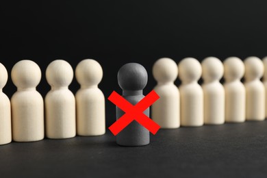 Image of Dismissal. One grey human figure with red cross among others on black table