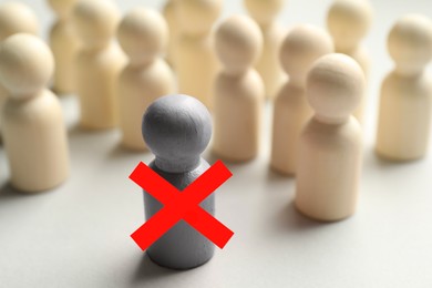 Image of Dismissal. One grey human figure with red cross among others on white table