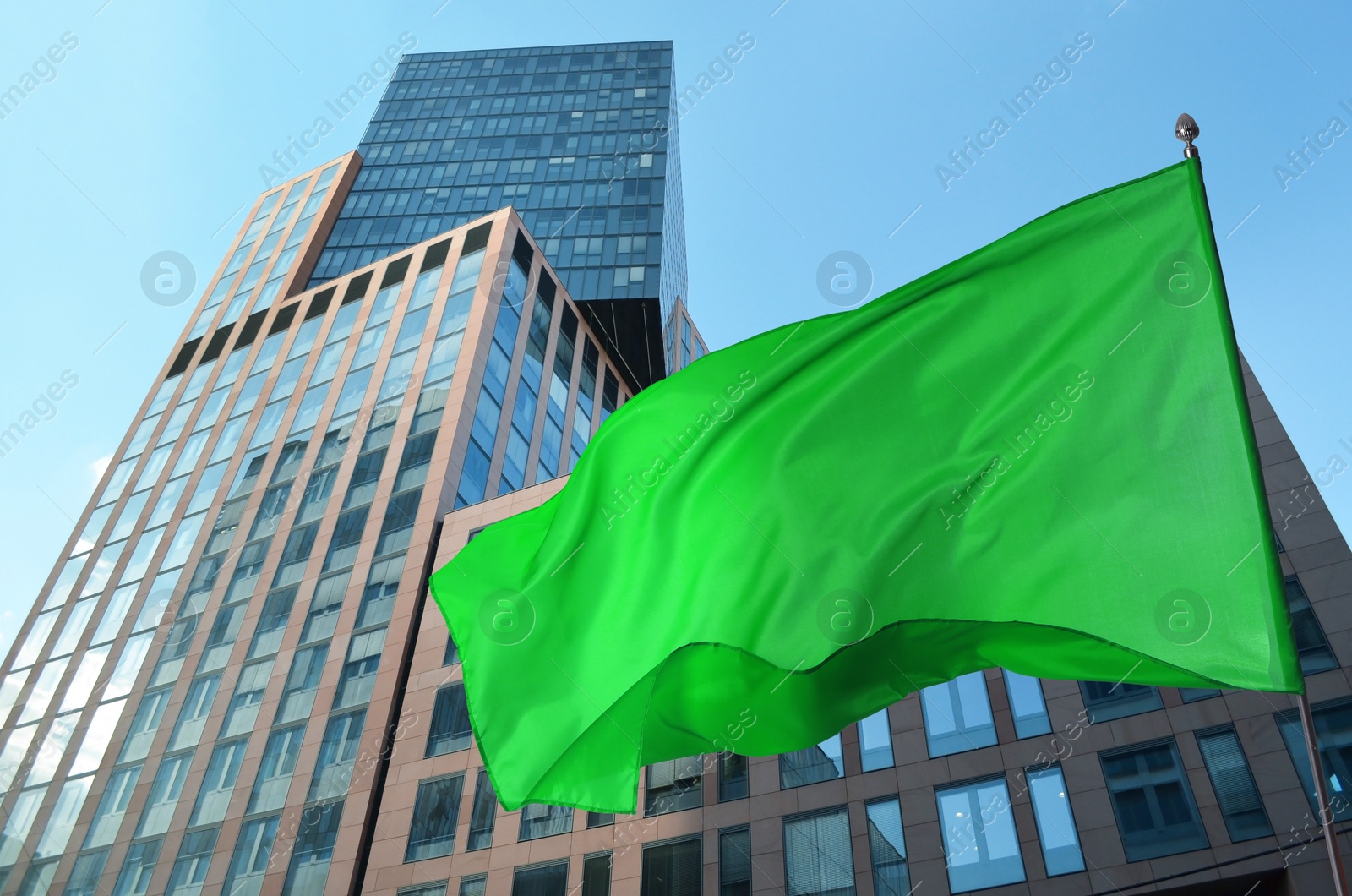 Bright green flag waving against building outdoors Image of Bright green flag waving against building outdoors