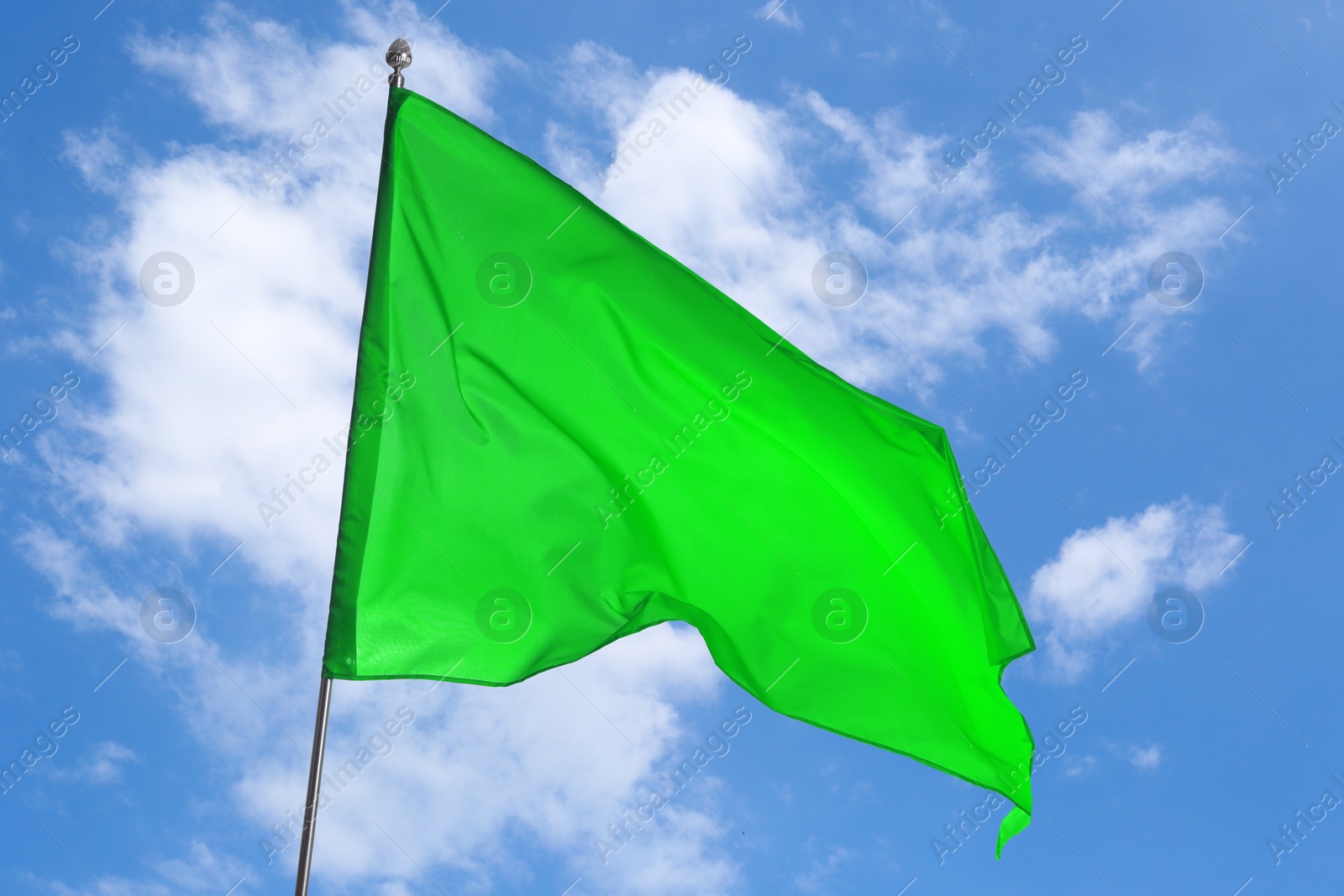 Green flag waving against blue sky outdoors Image of Green flag waving against blue sky outdoors