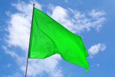 Image of Green flag waving against blue sky outdoors