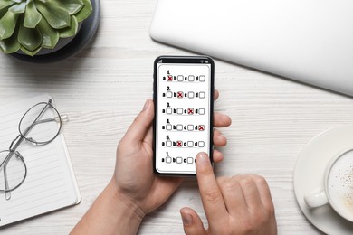 Image of Man passing online test on his mobile phone at table, top view
