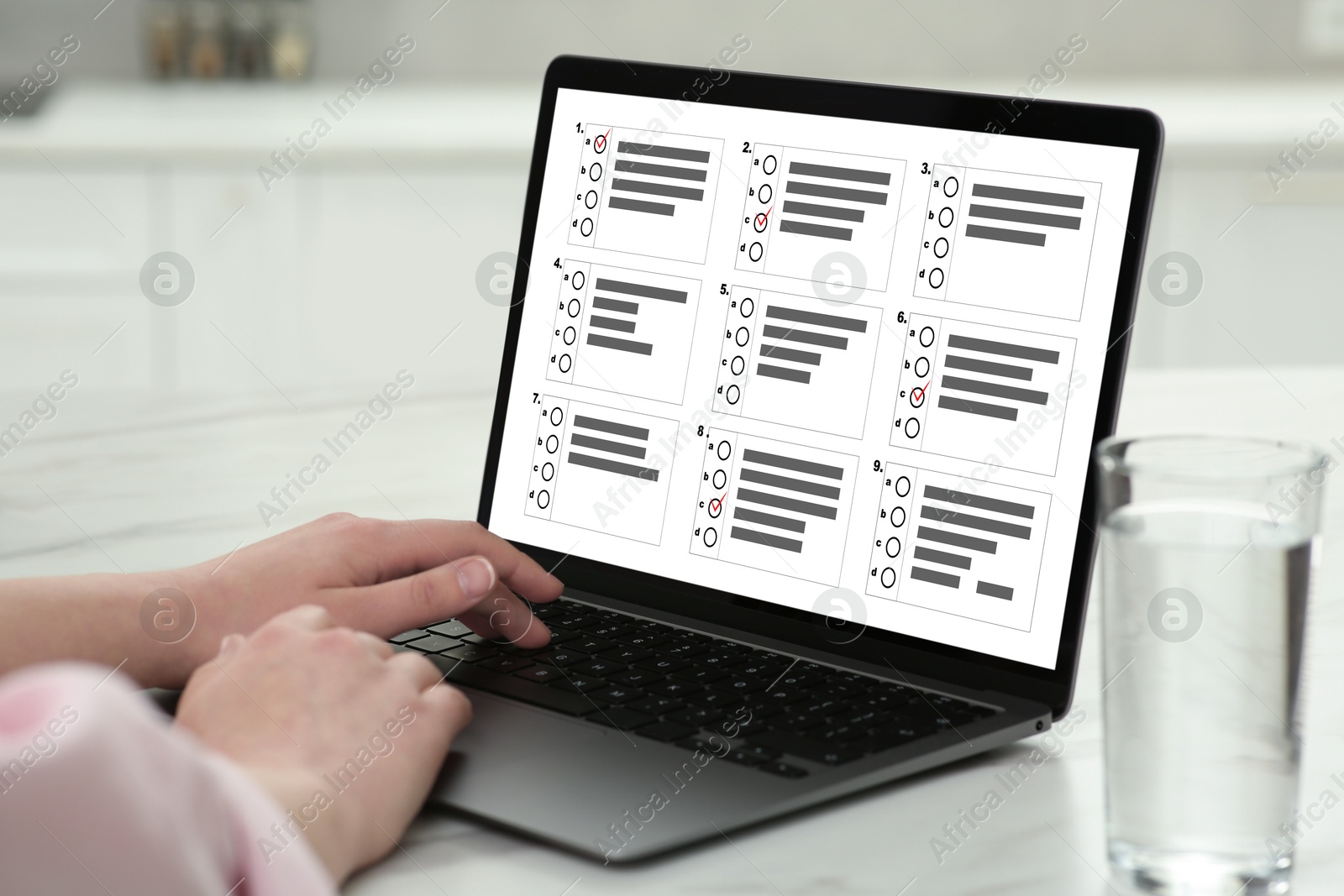 Woman passing online test on laptop at table, closeup Image of Woman passing online test on laptop at table, closeup